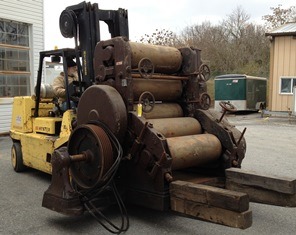 A 20,000 pound roll refining machine is moved with a forklift