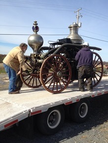 The horse-drawn steam pumper is secured to a trailer prior to moving